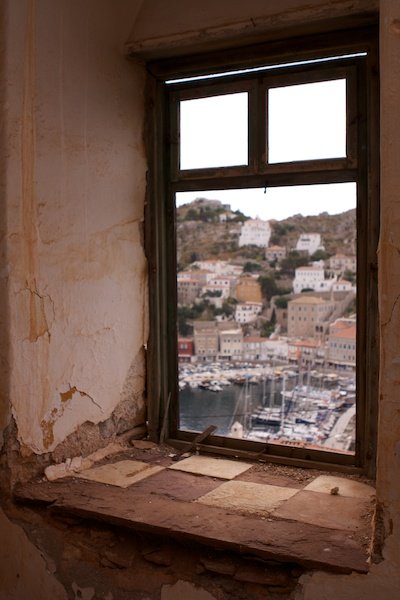 Фотография греческой гавани в обрамлении старого окна как пример композиции 