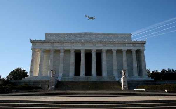 Фотография белого здания с колоннадой на фоне голубого неба