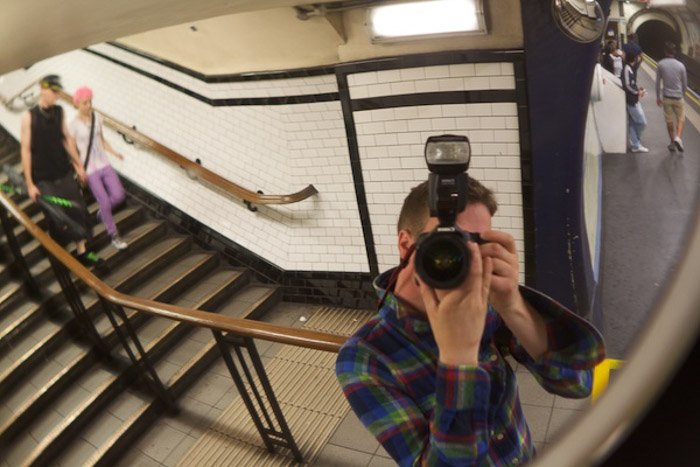 Фотограф, делающий автопортрет в зеркале станции метро, демонстрирует использование динамического напряжения в композиции фотографии