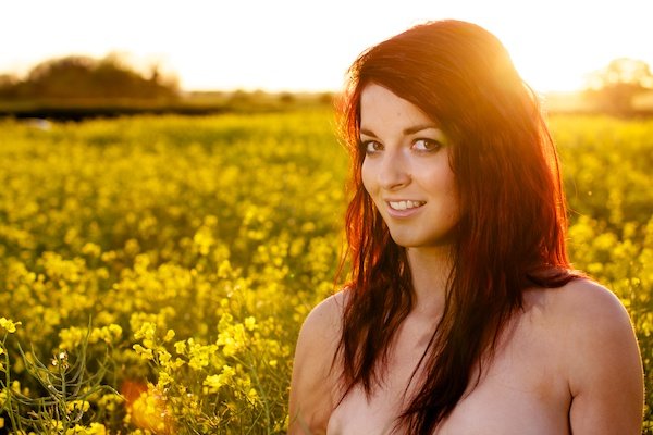 Фотография молодой женщины в поле желтых цветов демонстрирует редактирование с помощью черной точки