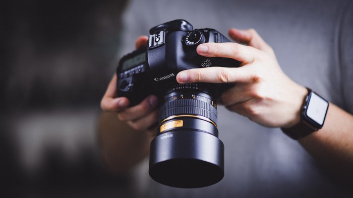 Фотограф меняет настройки на Canon EOS 5D