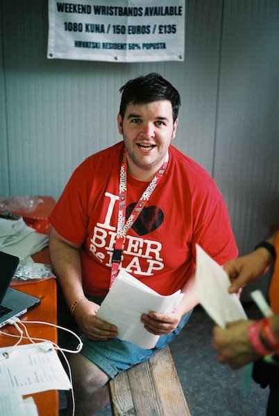 Мужчина в красной футболке смотрит в камеру - оконный свет для портретов