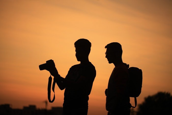 Два фотографа в силуэте на фоне заката