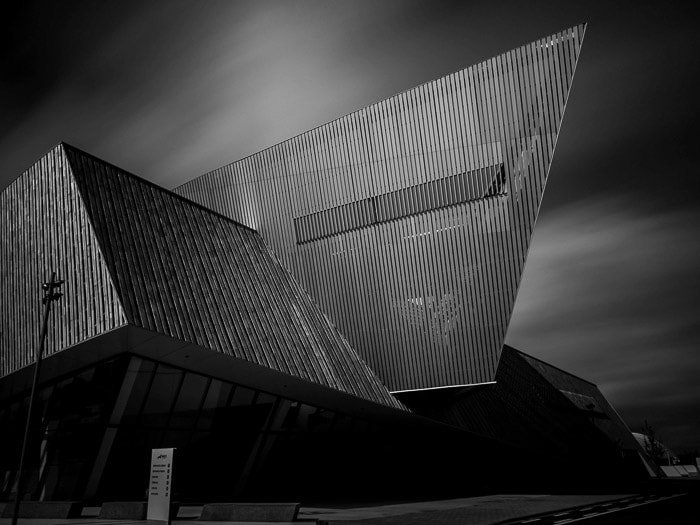 Черно-белая фотография нового конгресс-центра в Монсе, Бельгия, с размытым небом