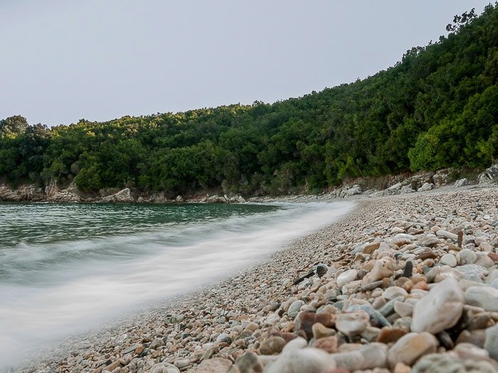 Волны разбиваются о берег пляжа Авлаки (Керкира, Греция), используя размытие движения в волнах