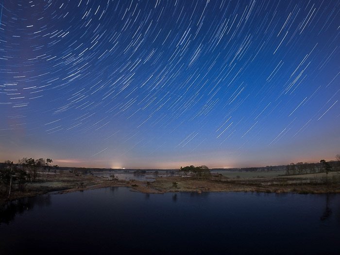 Ночной пейзаж над водой, креативное размытие звездных следов сверху