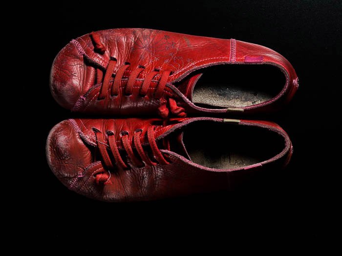 пара красных ботинок Camper на черном фоне