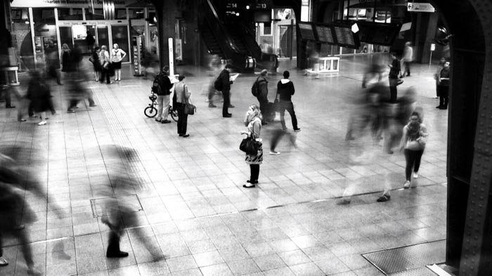Черно-белая фотография людей, проходящих по станции метро