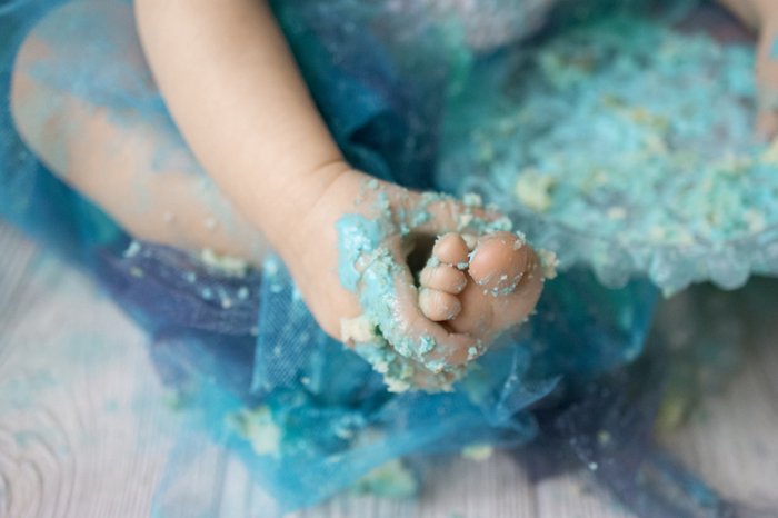 close up shot of the baby messily covered in cake during a Cute diy cake smash photoshoot