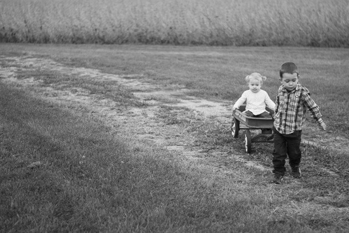 милая и ностальгическая откровенная фотография маленького мальчика и девочки, играющих в поле