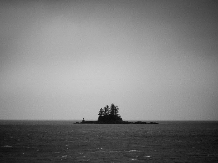 Береговая фотография: черно-белое изображение маленького острова вдали