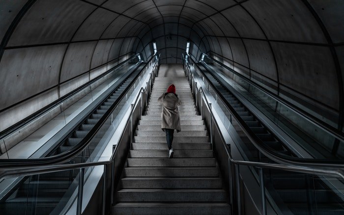 Человек поднимается по лестнице на станции метро