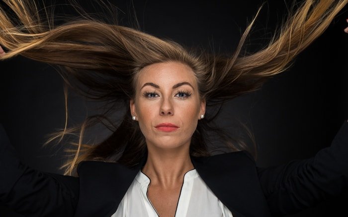 Портретное освещение: средний снимок женщины с развевающимися на ветру волосами