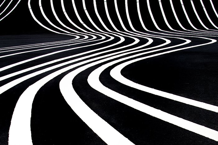 Высококонтрастная абстрактная фотография волнистых белых линий на черном фоне
