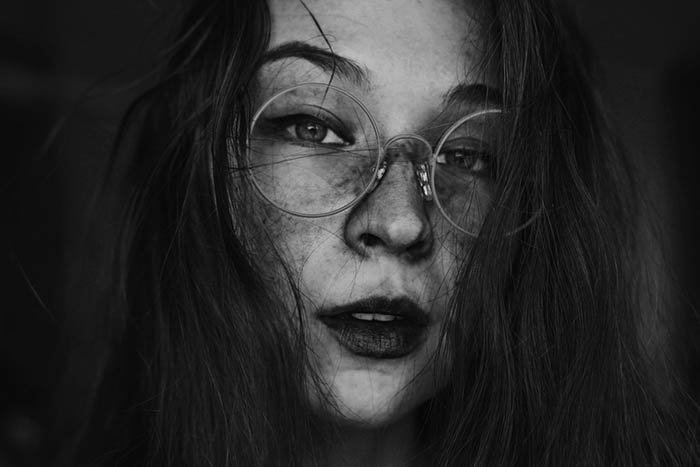 Творческий женский автопортрет в круглых очках.