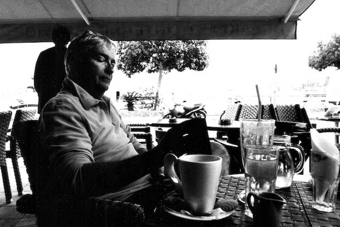 Человек, сидящий за столом, снятый на черно-белую фотопленку