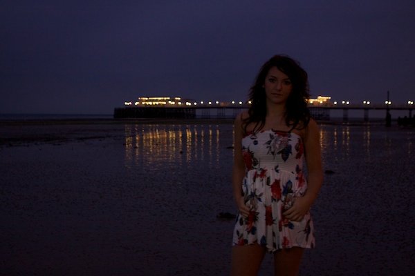 Портретная съемка девушки, стоящей на пляже. Сумеречная фотография.