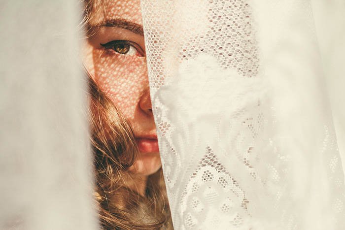портрет девушки, прячущейся за белой салфеткой, видна только половина лица
