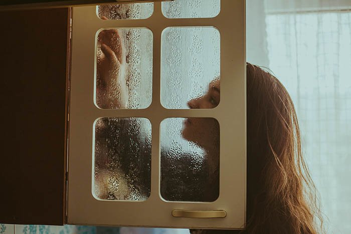 Фотография, сделанная через дверь шкафа молодой женщины. Автопортретная фотография