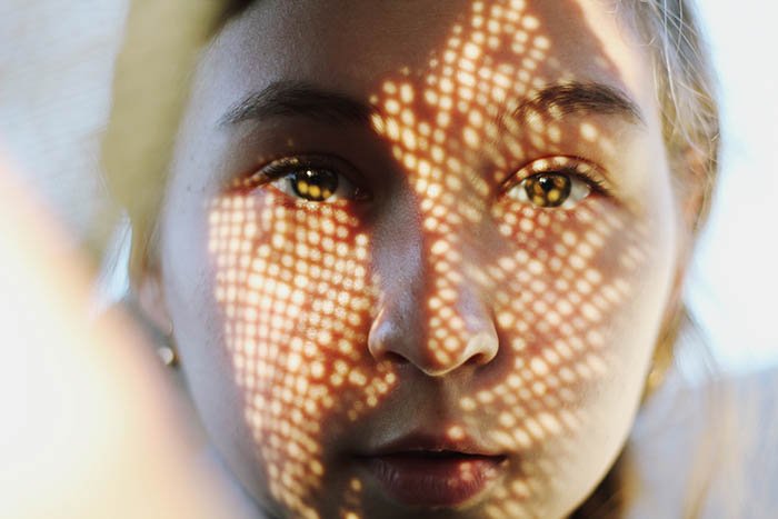  Автопортретная фотография крупным планом лица женщины, покрытого теневым узором