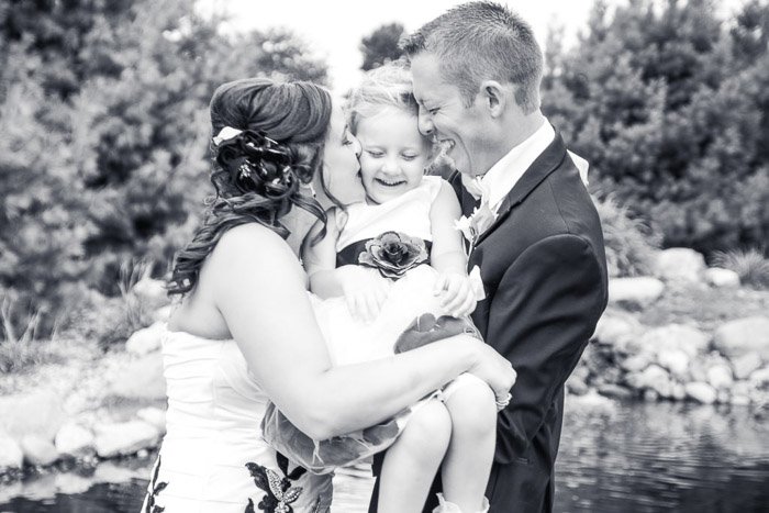 Черно-белое свадебное фото пары, держащей на руках маленькую девочку