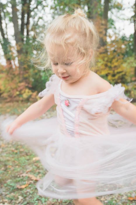Художественная фотография размытия движения маленькой девочки в кружащейся пачке