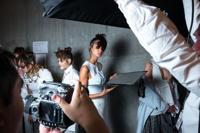 A behind the scenes view of a fashion shoot , using photography reflectors