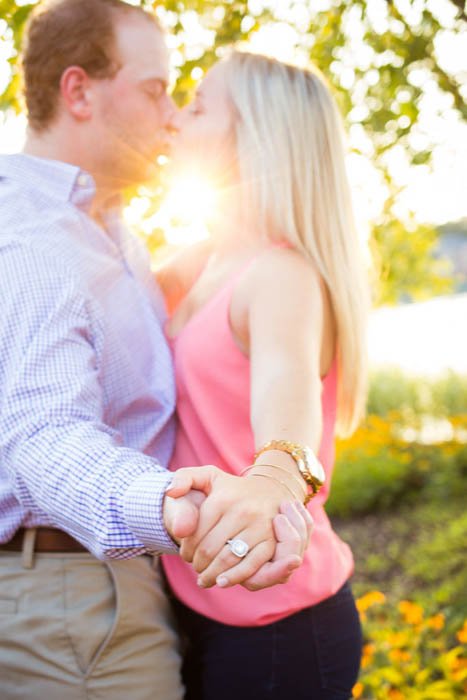 помолвочная фотография целующейся пары, внимание приковано к кольцу - фото сделано с использованием отражателей для освещения