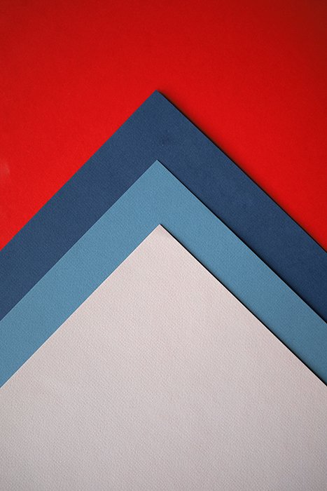 Абстрактная композиция из красной, синей и серой цветной бумаги