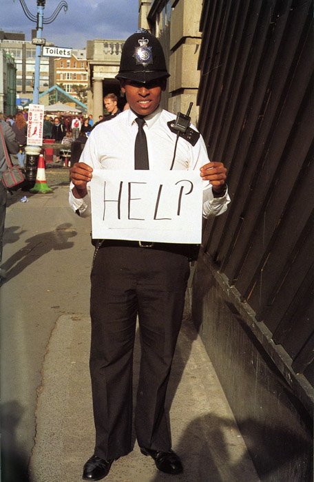 Полицейский держит табличку с надписью help by Gillian Wearing