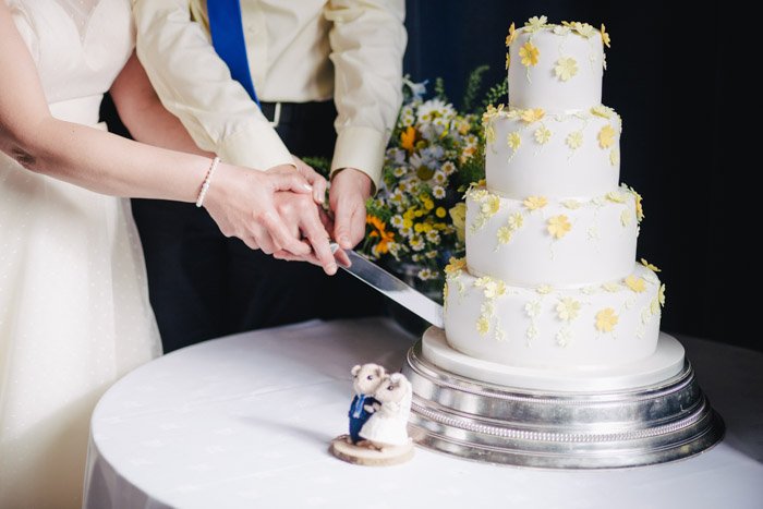 свадебная фотография пары, разрезающей торт