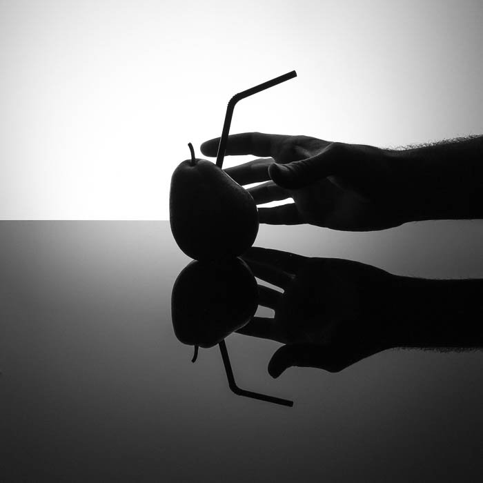 Теневая фотография в коммерческом стиле с соломинкой, воткнутой в грушу