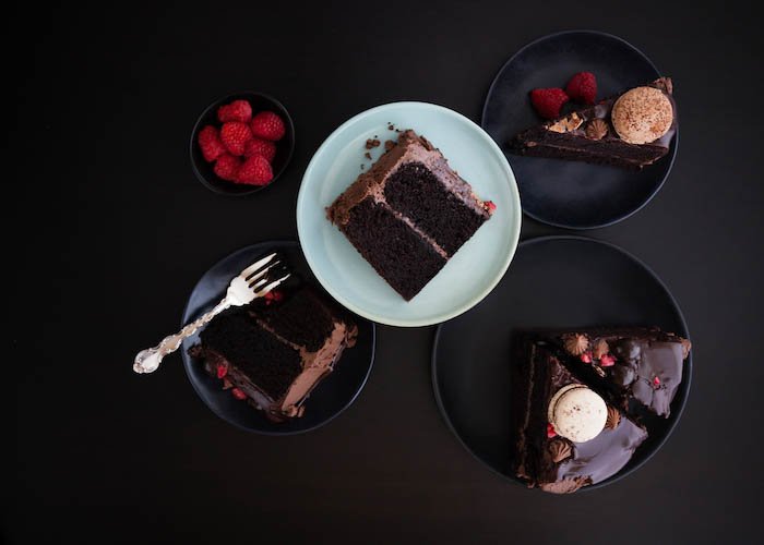 Кусочки шоколадного торта с ганашем на темном фоне