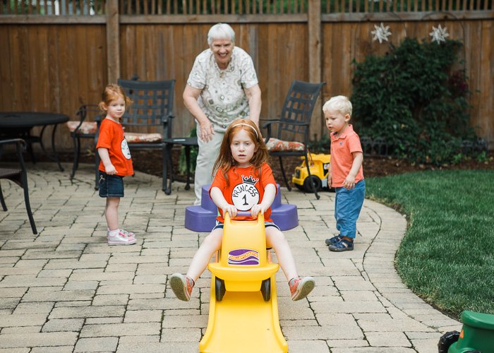 Candid portrait of a grandmother playing outdoors with three young grandchildren
