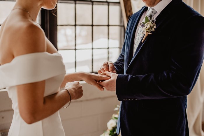 Крупный план жениха и невесты, держащихся за руки во время свадебной церемонии