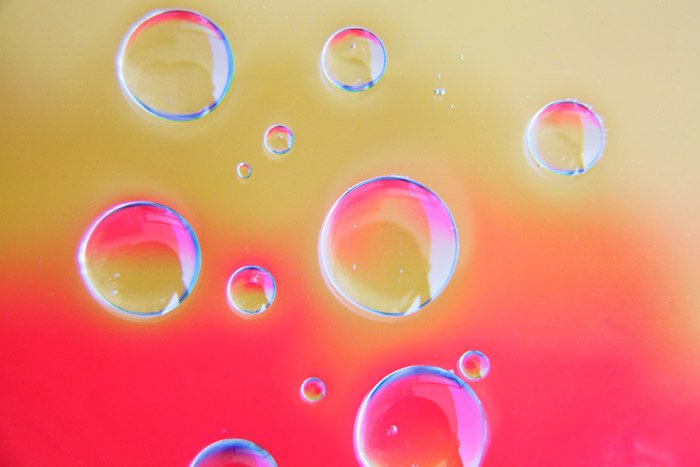 ярко-розовый и песочный фон с 13 прозрачными пузырьками, созданными по фотографии с помощью масла и воды