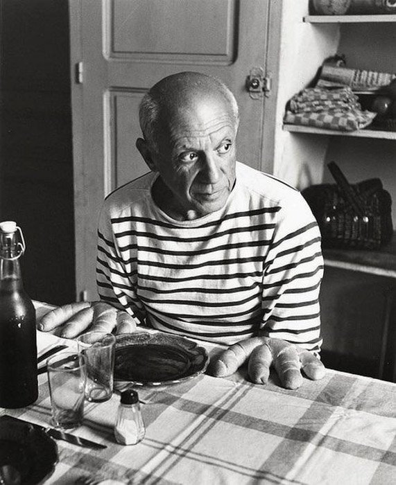 Роберт Дуано черно-белая фотография Пабло Пикассо, сидящего за столом и позирующего так, как будто хлеб - это его руки