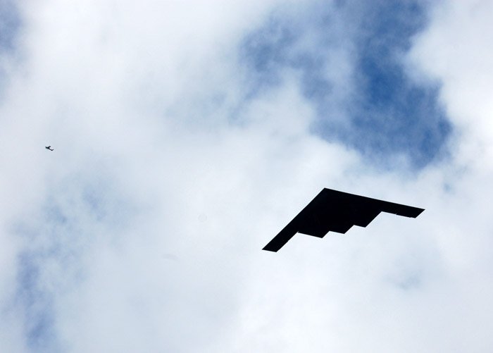 Фотография неба с самолетом в сопоставлении с бумажным самолетиком. 