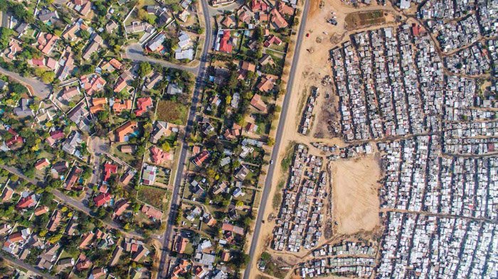 Аэрофотосъемка Джонни Миллера густонаселенного района по сравнению с более разреженным и зеленым районом слева