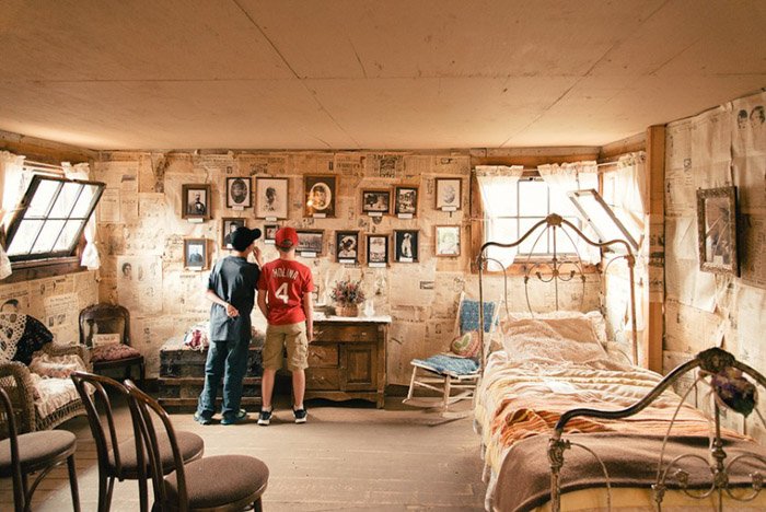 Фотография двух мальчиков в старомодной кровати на стене.