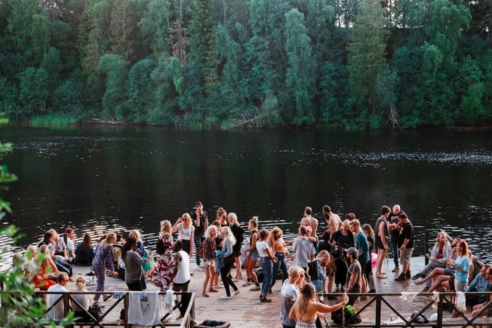 Очерк документальной фотографии группы людей на мероприятии у озера. 
