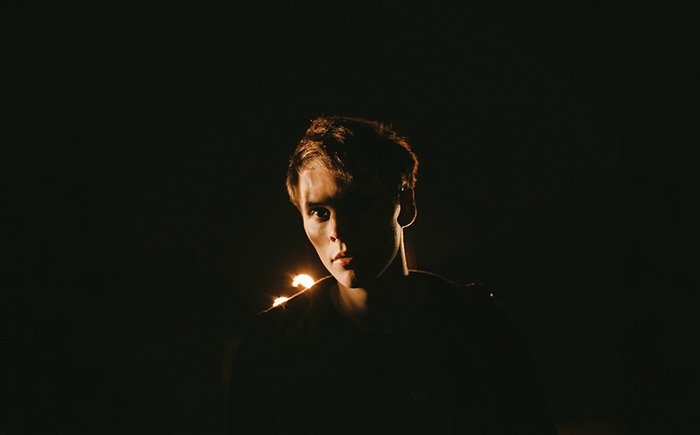 Ночной портрет мужчины с освещенной одной стороной лица, темный фон.