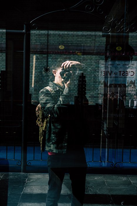 Фотография человека, фотографирующегося в отражении в витрине магазина. Советы по съемке автопортрета.