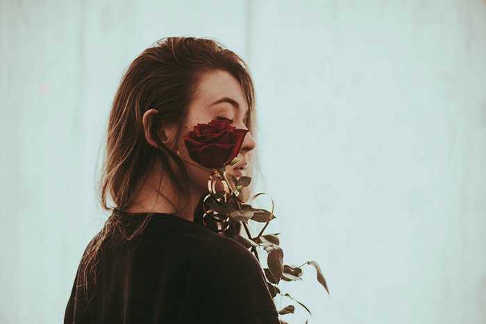 Портретная фотография девушки, держащей розу у лица. Советы по портретной фотографии.