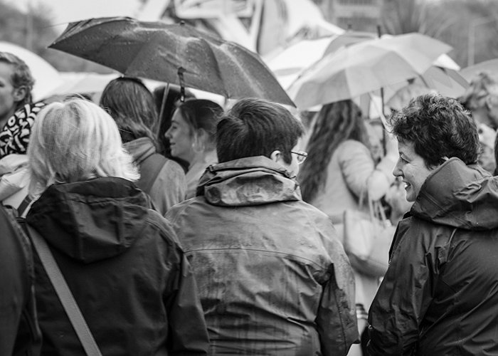 Черно-белая уличная фотография группы взрослых под дождем. Фотография дождя