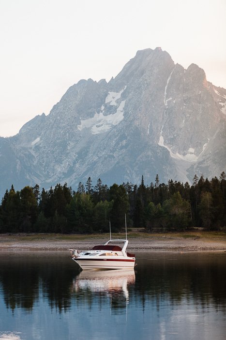 Безмятежное изображение лодки на озере с горой позади