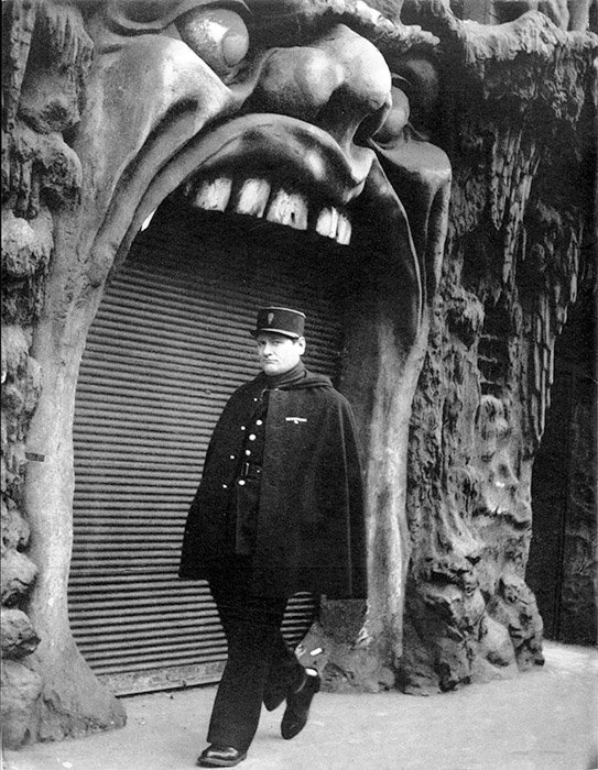 Черно-белая фотография мужчины, проходящего мимо бара L'Enfer в Париже