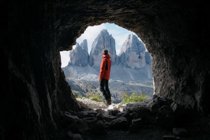 Пеший турист в естественном обрамлении пещеры на переднем плане