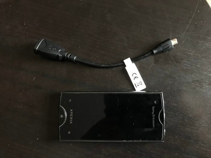 Снимок Sony Xperia Ray и кабеля microUSB OTG на черном столе