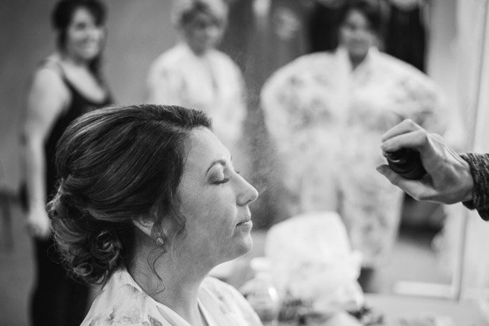 Черно-белая фотография невесты, делающей макияж